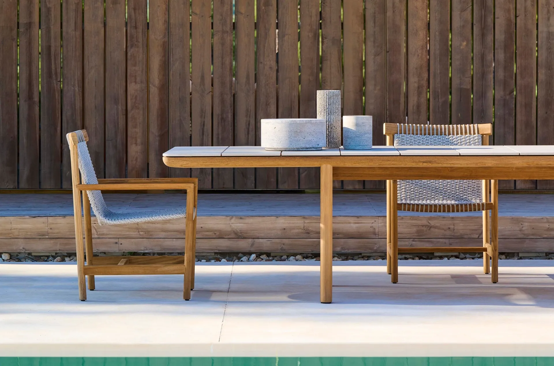 Tribù Amanu lounge chair in solid teak with a Canax sling seat on an outdoor terrace
