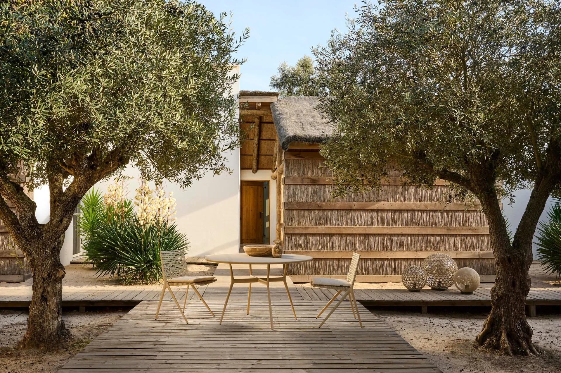 Tribù Branch armchairs with hand-woven backs and branching powder-coated legs in a garden