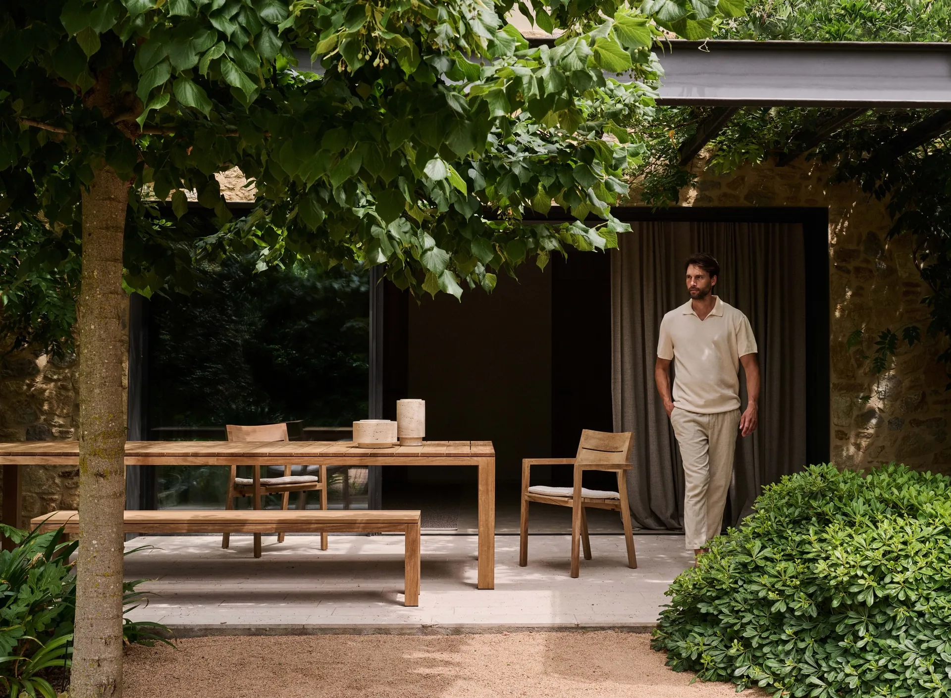 Tribù Kos solid teak armchairs and dining table on a sunlit terrace
