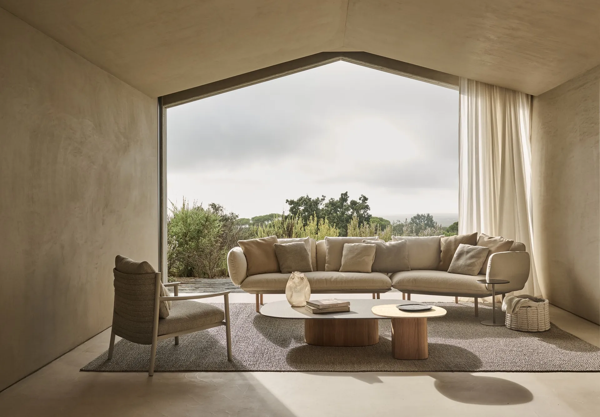 Tribù Lucca woven armchairs around the ceramic-top dining table on a garden terrace