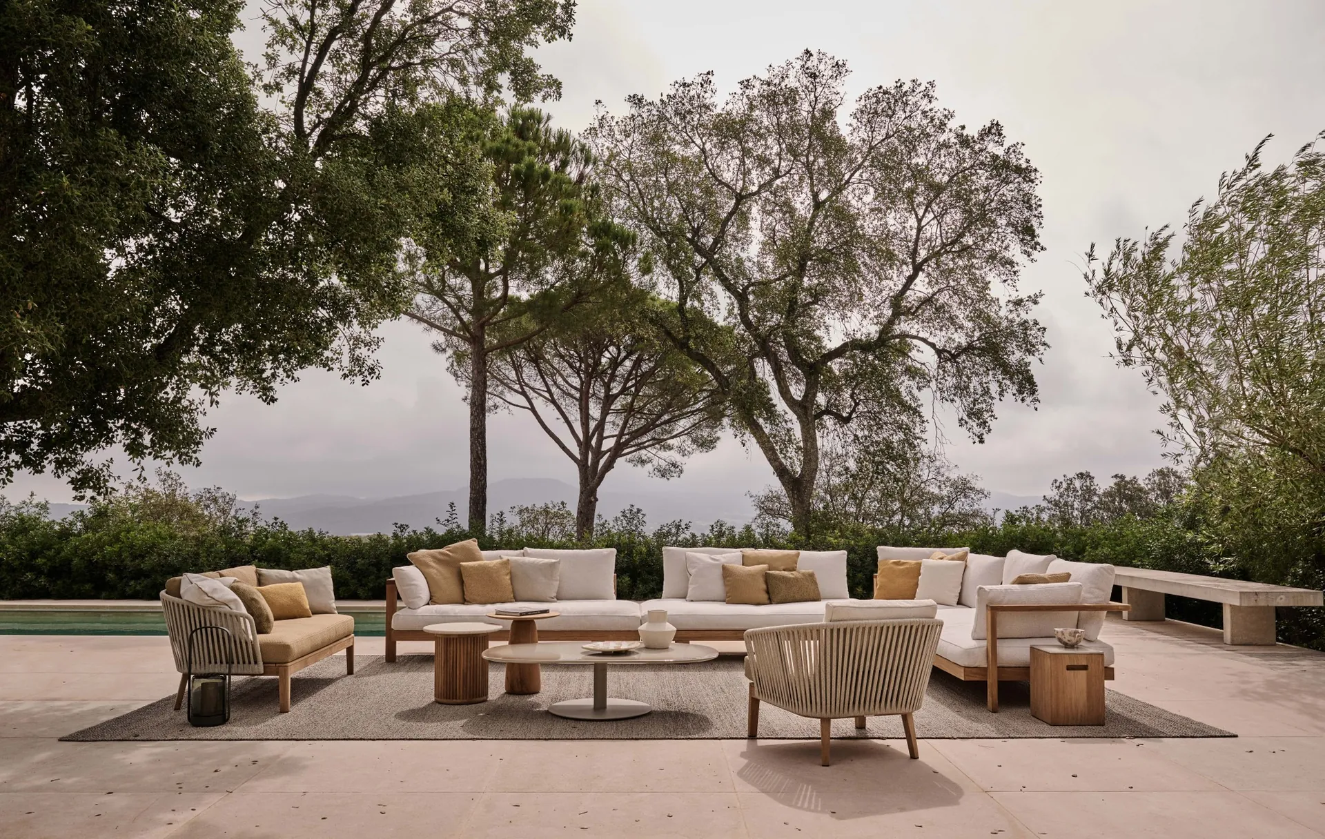 Tribù Pure 2-seat sofa and Pure armchair with a lounger beside a pool